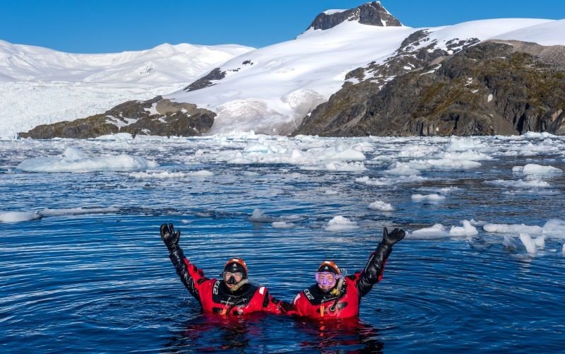 Schnorchler, schneebedeckte Berge und Eisschollen Antarktis